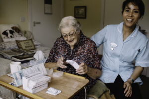 A care assistant helps a resident taking medication